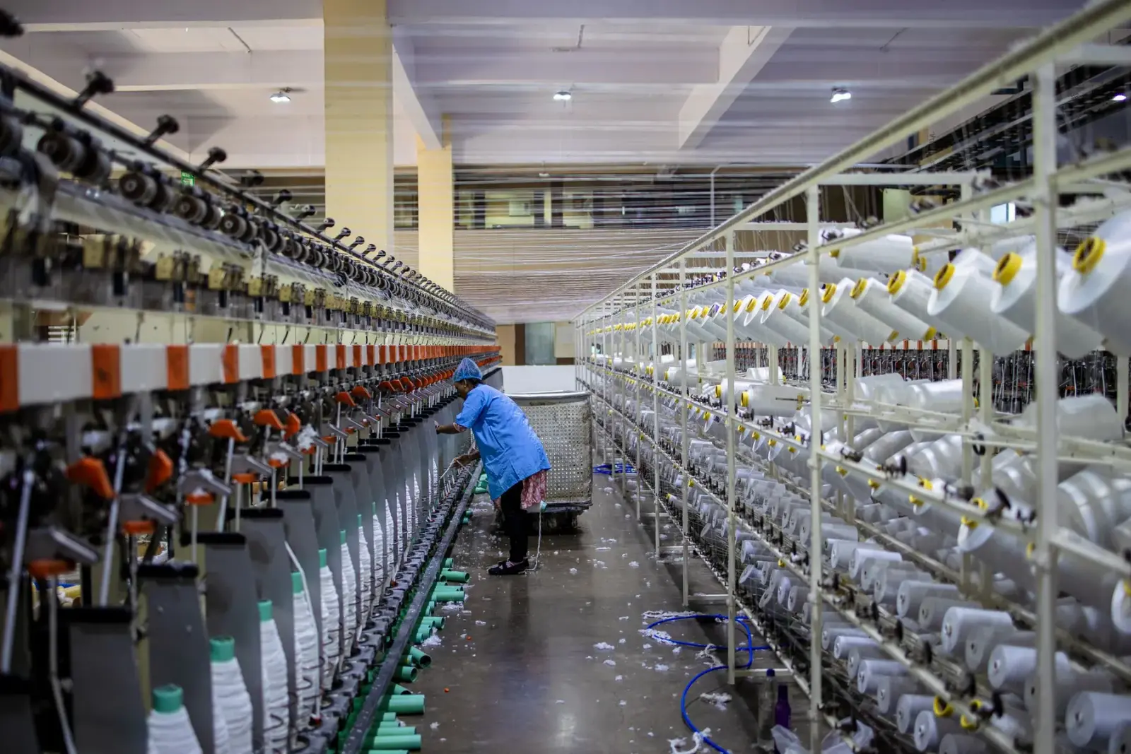 Công nhân dệt vận hành máy trong nhà máy hiện đại
