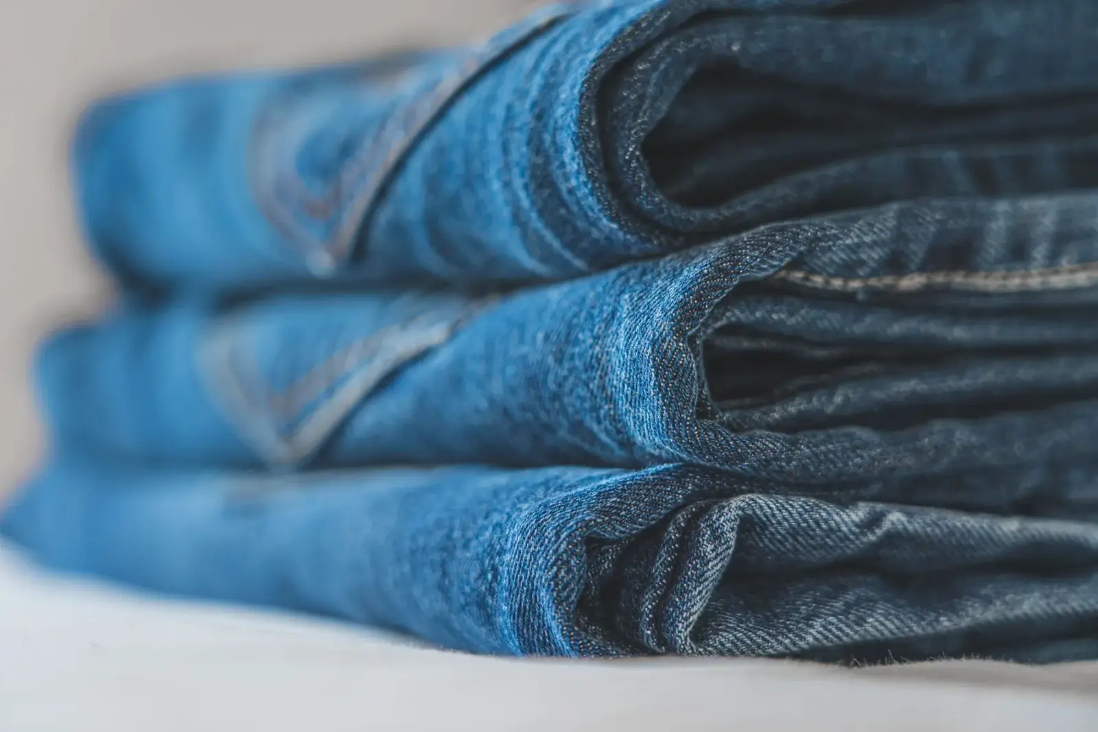Chồng quần jean xanh gấp vuông vắn xếp chồng lên nhau