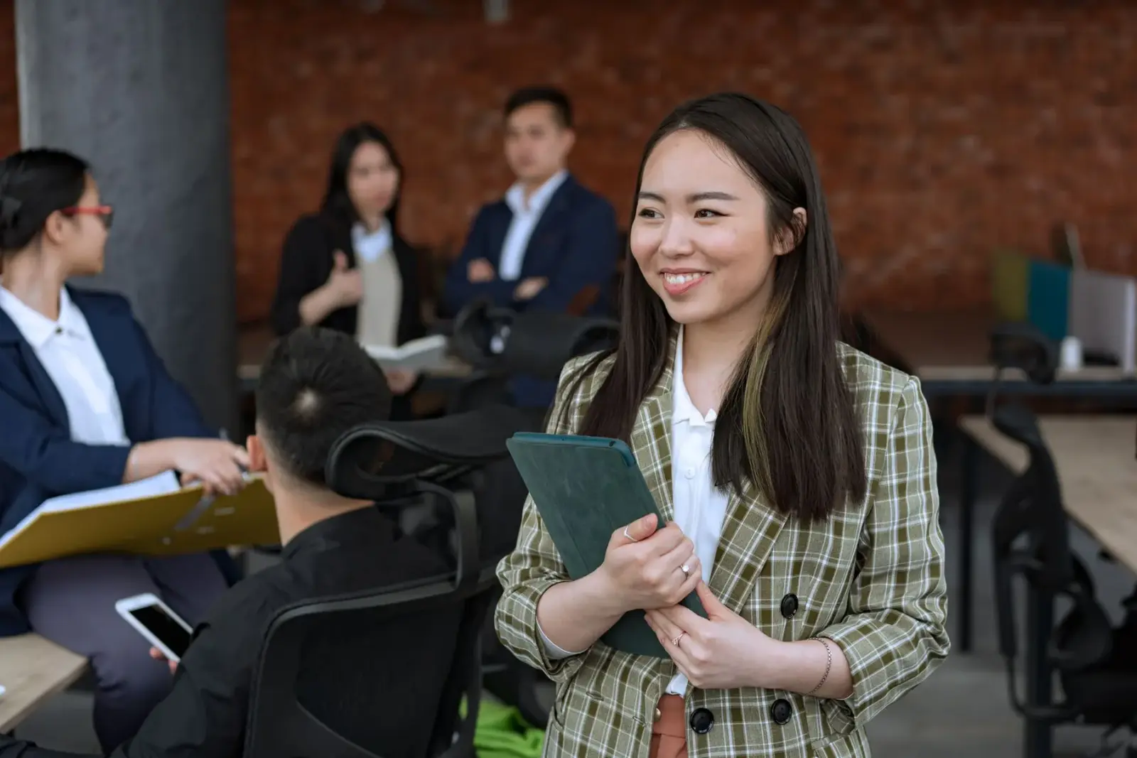 Người phụ nữ châu Á cầm máy tính bảng trong văn phòng